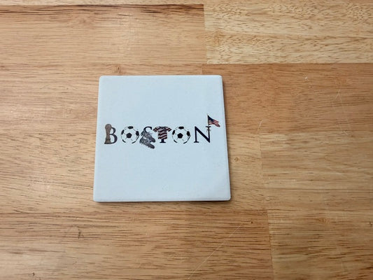 A square white coaster with the word 'BOSTON' spelled out in black and filled with sports-themed illustrations, 